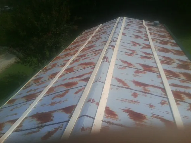 Rusted metal roof panels with new wood purlins before replacement — Storm Damage Roof Repair in Port Neches by Roofing Brothers