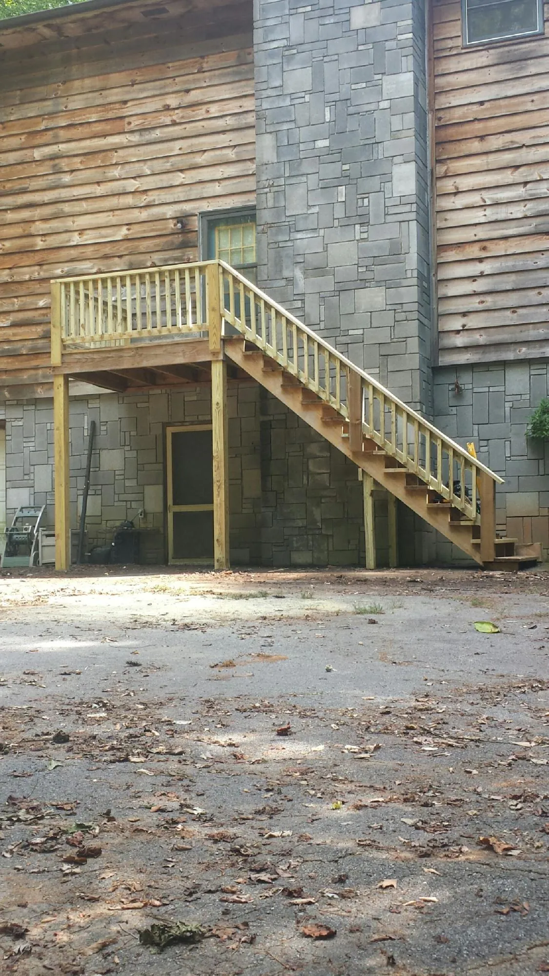 New pressure treated deck and stair landing on a log home in Port Neches